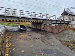 na zdęciu radiowóz widać liście na drodze i padający deszcz