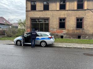 na zdjęciu policjanci radiowóz przy pustostanie