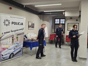 na zdjęciu oficer prasowy wyczytuje wyróżnionych policjantów