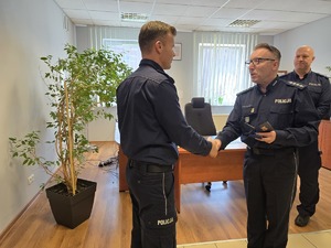 na zdjęciu wiceprzewodniczący wręcza medal komendantowi