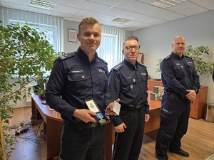 na zdjęciu komendant i wiceprzewodniczący komendant pokazuje medal