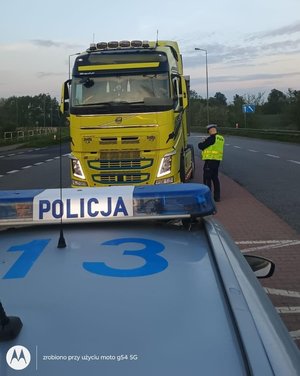 na zdjeciu policjant kontroluje tira