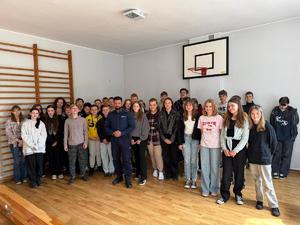 na zdjęciu policjant z uczniami