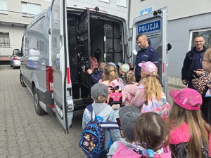 na zdjęciu policjanci pokazują duży radiowóz przedszkolakom