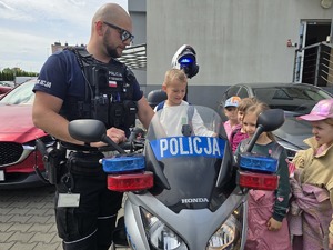 na zdjeciu chłopczyk na motocyklu policyjnym