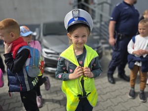 na zdjęciu dziewczynka ubrała czapkę policyjna i kamizelkę