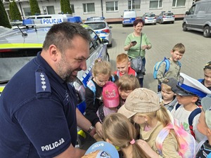na zdjęciu policjant rozdaje odblaski