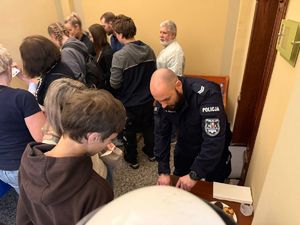na zdjeciu policjant przy stanowisku pokazuje sprzęt policyjny