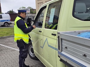 na zdjeciu policjant kontroluje pojazd