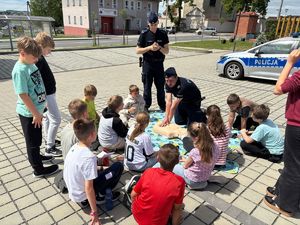 na zdjeciu policjan wyknuje pierwsza pomoc na fantomie
