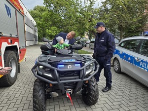 na zdjeciu dziecko z tata na quadzie