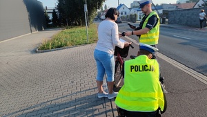 na zdjęciu policjanci rozmawiają z rowerzystką