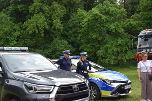 na zdjęciu policjanci z ruchu drogowego przy radiowozie