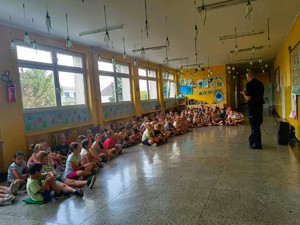 na zdjeciu dzielnicowy z uczniami na pogadance