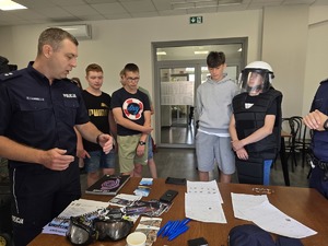 na zdjeciu policjant przy stoisku z uczniami
