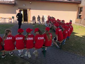 na zdjęciu policjant i dzieci na obozie