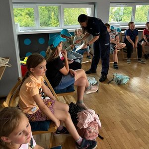 na zdjęciu policjantka rozmawia z dziećmi