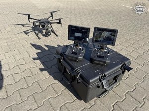 na zdjęciu dwa monitory od dronu a dron stoi obok