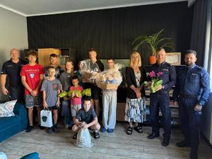 na zdjęciu dzieci z placówki oraz policjanci przekazujący podarunki