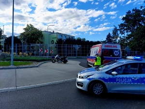 na zdjęciu miejsce zdarzenia pogotowie stoi i policja policjantka legitymuje motocyklistę