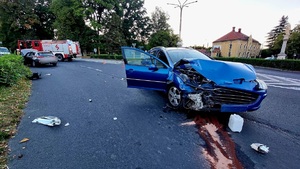 na zdjęciu rozbity peugeot na skrzyżowaniu koloru niebieskiego