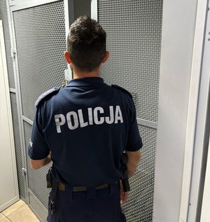 na zdjęciu policjant stoi tyłem