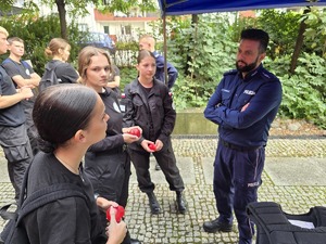 na zdjęciu uczniowie klasy mundurowej rozmawiają policjantem