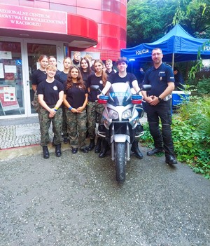 na zdjęciu policjant z uczniami przy motocyklu