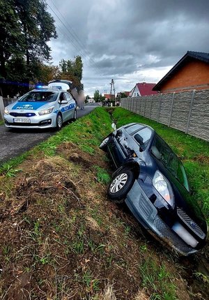 na zdjęciu samochód w rowie i policja obok