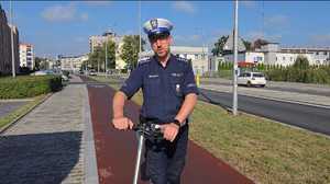 na zdjęciu policjant ruchu drogowego jedzie na hulajnodze elektrycznej