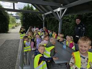 na zdjęciu przedszkolaki i policjant ruchu drogowego