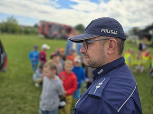 na zdjeciu policjant a przy nim dzieci