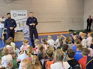 na zdjęciu komendant i profilaktyk witają dzieci