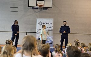na zdjęciu policjanci tłumacza dzieciom zasady bezpiecznej drogo do szkoły