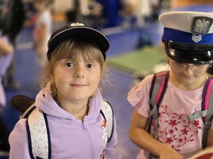 na zdjęciu dziewczynka w czapce policyjnej