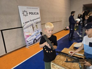 na zdjęciu chłopczyk ogląda broń