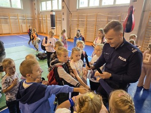 na zdjęciu komendant rozdaje odblaski