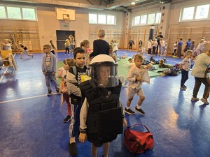 na zdjeciu chłopczyk w umundurowaniu ćwiczebnym