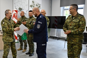 na zdjęciu policjant i strażnicy graniczni