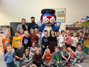 na zdjęciu policjant z dziećmi i sznupek