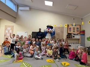 na zdjęciu policjant z dziećmi i sznupek