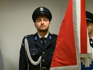 na zdjeciu policjant ze sztandarem