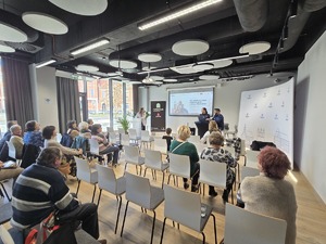 na zdjęciu seniorzy i policjantka opowiadająca o oszustwach