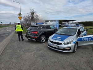 na zdjęciu policjant kontroluje pojazd audi