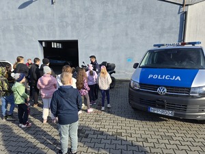 na zdjęciu dzieci policjant i radiowóz