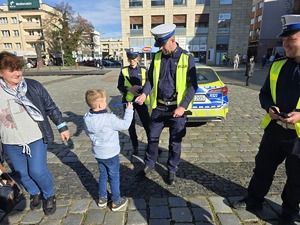 NA ZDJECIU POLICJANCI ROZDAJA ODBLASKI