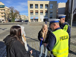 NA ZDJĘCIU MLODZIEZ Z ODBLASKAMI I POLICJANCI