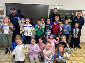 na zdjęciu dzielnicowi z dziećmi na pogadance w szkole