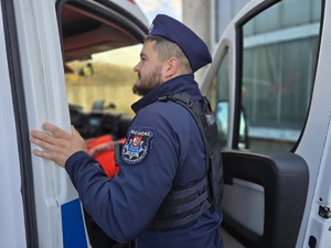 na zdjęciu widać jak policjant pomaga osobom poszkodowanym w wypadku