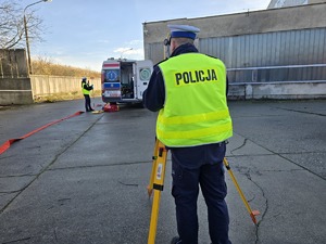 na zdjęciu policjant wykonuje czynności procesowe do wypadku drogowego używa tachimetru